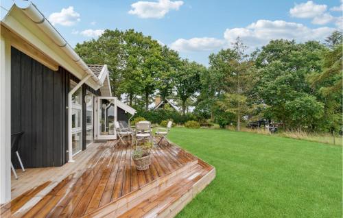 a wooden deck with chairs and a lawn at 2 Bedroom Beautiful Home In Samsø in Ballen