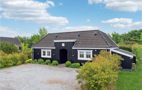 a black house with a black roof at Tisvildelund in Vejby