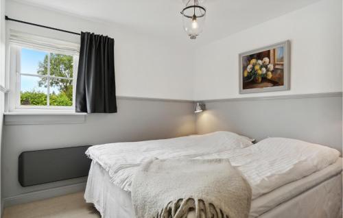 a white bedroom with a bed and a window at Tisvildelund in Vejby