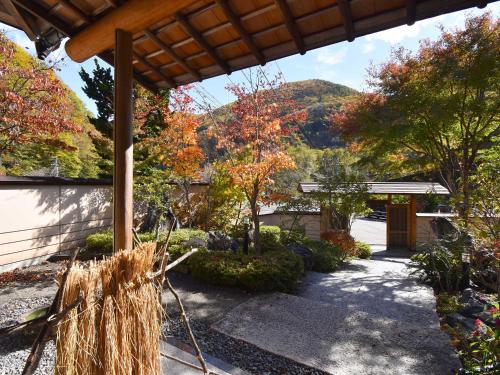 a house with a garden with fall foliage at Keiryuso Siorie in Matsumoto