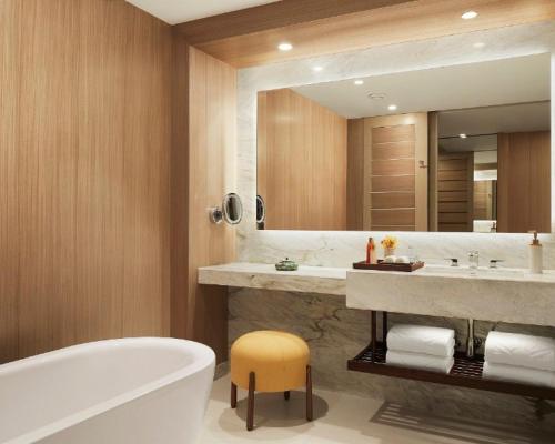a bathroom with a tub and a large mirror at Taj Cidade de Goa Horizon, Goa in Panaji