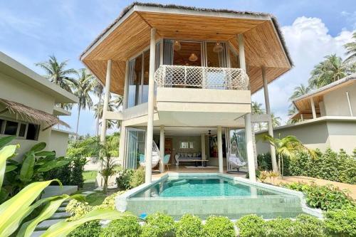 a villa with a swimming pool in front of a house at Villa Cefloralie - A Tranquil Retreat in Koh Samui in Koh Samui