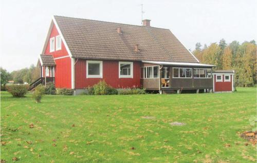 a red house with a green field in front of it at Awesome Home In Bolmsö With Sauna in Bolmsö