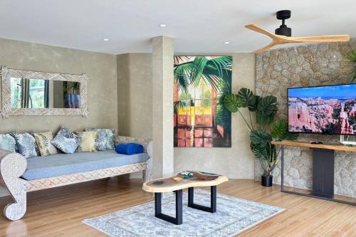 a living room with a couch and a tv at Villa Cefloralie - A Tranquil Retreat in Koh Samui in Koh Samui