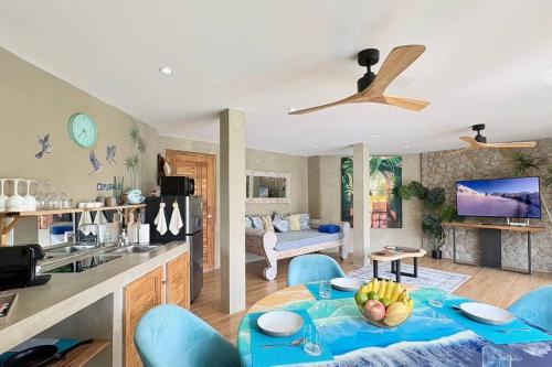 a kitchen and living room with a table and blue chairs at Villa Cefloralie - A Tranquil Retreat in Koh Samui in Koh Samui