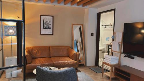 a living room with a couch and a television at Chill Roof Hotel in Taipei