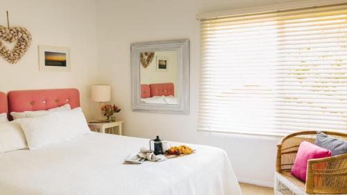 Un dormitorio con una cama blanca y una ventana. en Malolo Costal Retreat , Wifi Accom Holidays, en Macmasters Beach