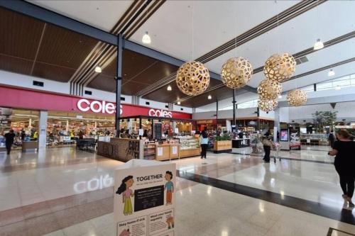 a shopping mall with a cvs sign and people in it at Cosy 5 x bedroom Kellyvil Ridge in Kellyville