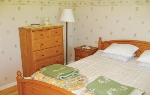 a bedroom with a bed with a dresser and green towels at Awesome Home In Älgarås With Wifi in Hallerud