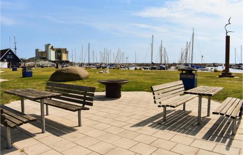 three benches and a picnic table in a park with boats at 1 Bedroom Amazing Apartment In Ystad in Ystad