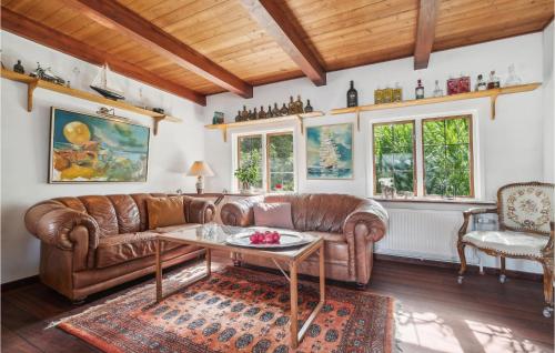 a living room with a leather couch and a table at Nice Home In Nexø With Wifi in Neksø