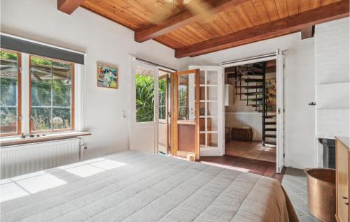 a bedroom with a large bed and windows at Nice Home In Nexø With Wifi in Neksø