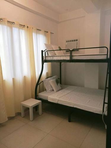 a room with two bunk beds and a stool at Cozy 2-Bedroom Apartment in Boracay