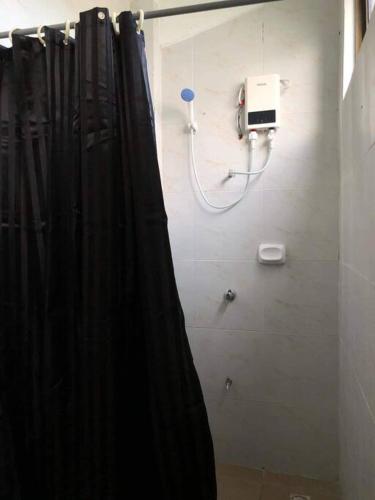 a bathroom with a shower curtain and a phone at Cozy 2-Bedroom Apartment in Boracay