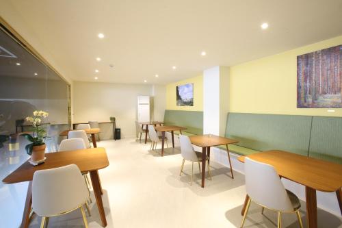 a waiting room with wooden tables and white chairs at Hotel rein in Gyeongju