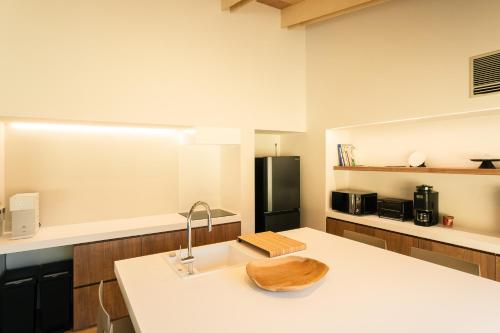 a kitchen with a sink and a black refrigerator at mysa yamanakako in Yamanakako