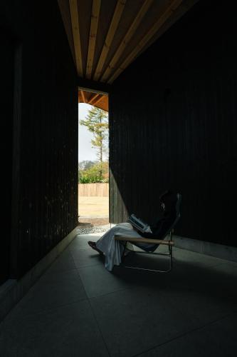a woman sitting in a chair in a dark room at mysa yamanakako in Yamanakako