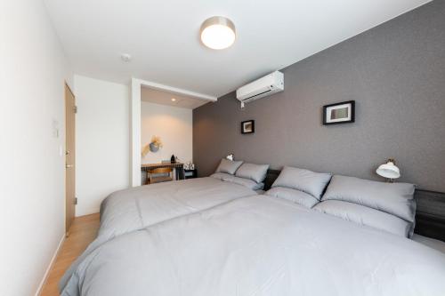 a bedroom with a large white bed with pillows at The Verite in Asahikawa