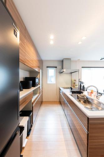 a kitchen with wooden cabinets and a counter top at The Verite in Asahikawa