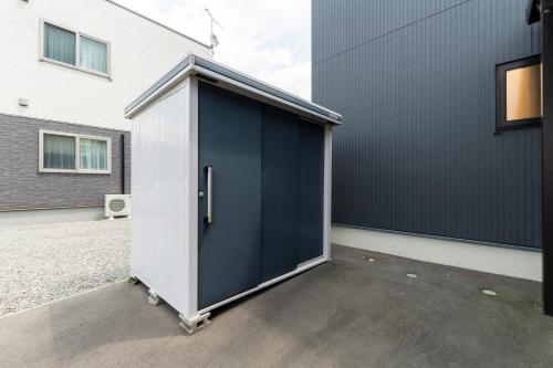 a large blue and white container in front of a building at The Verite in Asahikawa