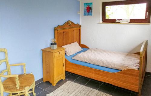 a small bedroom with a bed and a chair at Nice Home In Drochtersen in Drochtersen