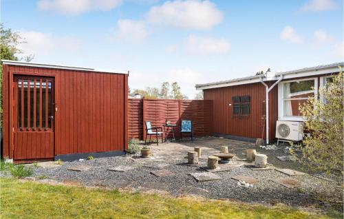 a backyard with a red fence and a table and chairs at 2 Bedroom Pet Friendly Home In Stege in Stege