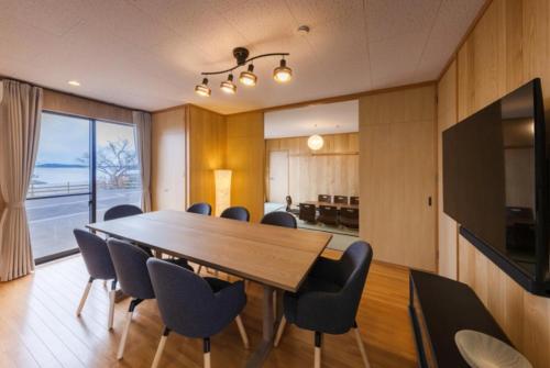 a conference room with a large wooden table and chairs at Tabinoteitaku Miyagi Matsusima in Matsushima