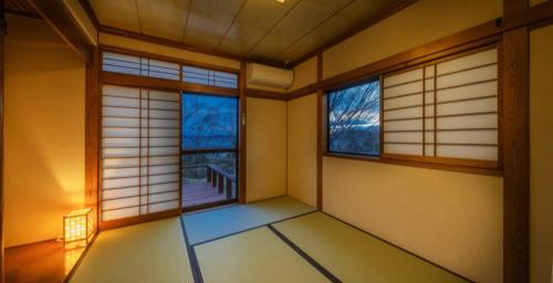 an empty room with two windows in a room at Tabinoteitaku Miyagi Matsusima in Matsushima