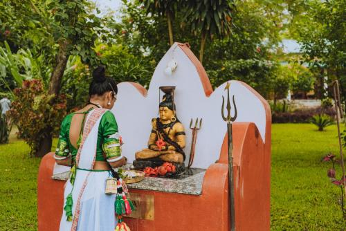 a woman standing next to a statue of a man at Machan Country Villa in Chitwan