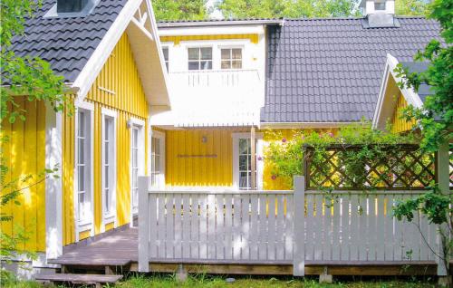 a small yellow house with a white fence at Amazing Home In Köpingsvik With Sauna in Köpingsvik