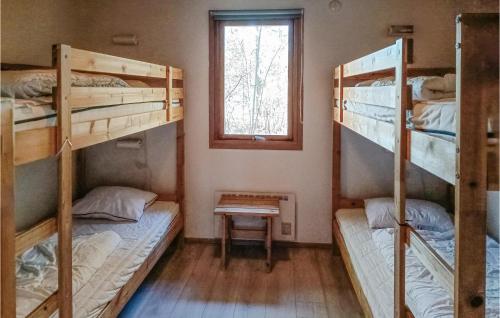 a room with three bunk beds and a window at Amazing Home In Köpingsvik With Sauna in Köpingsvik