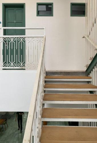 a person walking down the stairs of a building at Binumar Guest House in Pekalongan