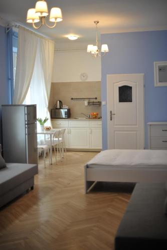 a bedroom with a bed and a kitchen with a table at Vinci in Krakow