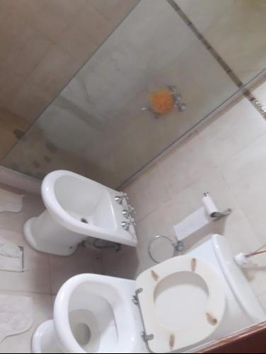 a bathroom with a toilet and a sink and a mirror at Casa de verano confortable in Villa Las Rosas