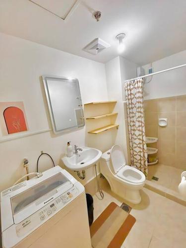 a bathroom with a toilet and a sink at Condo in Las Piñas- The Suite Spot Alabang in Manila