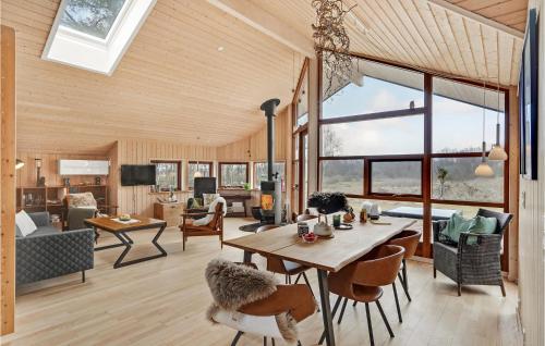 a dining room and living room with a table and chairs at Holiday Home Tangvej Ørsted Iv in Kare