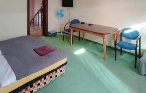 a bedroom with a bed and a table and chairs at 7 Bedroom Stunning Home In Nowe Warpno in Nowe Warpno