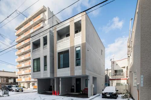 a white building with a car parked in front of it at Nakajima Nouveau in Sapporo