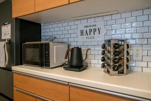 a kitchen counter with a microwave and a sign that reads happy take at Nakajima Nouveau in Sapporo
