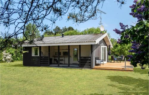 a small cottage with a deck and lawn at Holiday Home Mælkebøttevej Nakskov in Kappel