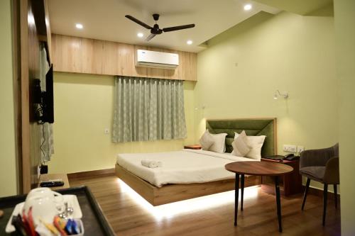a bedroom with a bed and a table in a room at The Infigo in Beherāpāt