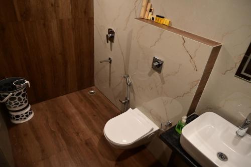 a bathroom with a white toilet and a sink at The Infigo in Beherāpāt