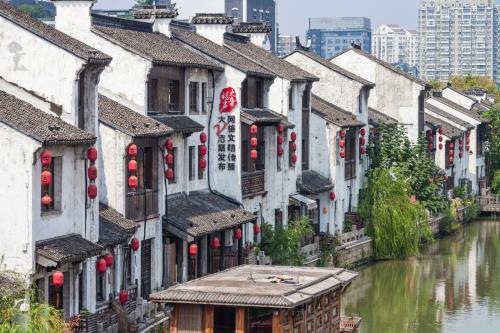 a row of buildings next to a river with red lanterns at Holiday Inn Wuxi Taihu New City by IHG in Wuxi