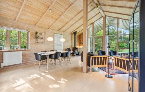 a dining room with a table and chairs and windows at Three-Bedroom Holiday Home In Oksbol in Oksbøl