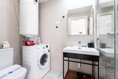ein Badezimmer mit Waschmaschine und Waschbecken in der Unterkunft Apartamento en el Palo in Málaga