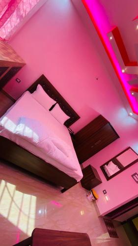 a bedroom with a bed with a pink ceiling at The Bastian Palace in Rānchī