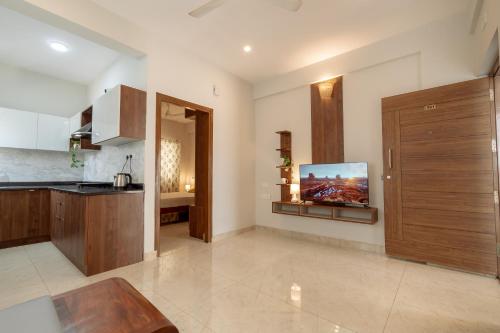 a kitchen with a tv on the wall at Ega Orchid, Luxury Apartment in Brookefield in Bengaluru