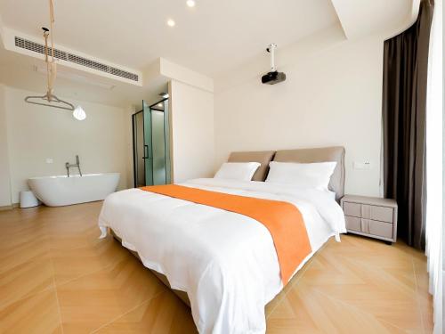 a bedroom with a large bed and a bath tub at 西湖柒涧锦月民宿 Lakeside Moon Retreat in Hangzhou