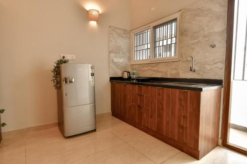 a kitchen with a refrigerator and a sink at Ega Orchid, Luxury Apartment in Brookefield in Bengaluru