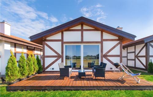 ヤロスワビエツにあるBeautiful Home In Jaroslawiecの木製デッキ(椅子付)が備わる家